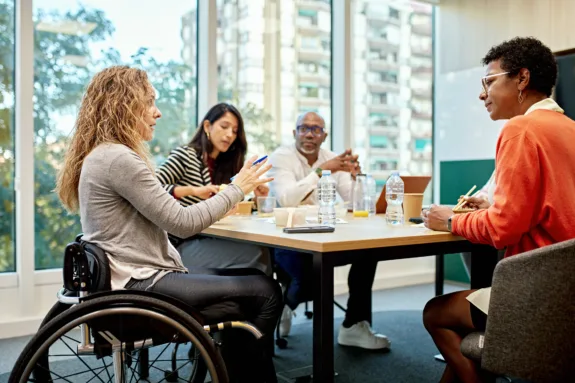 Diverse group of corporate professionals sitting around conference table